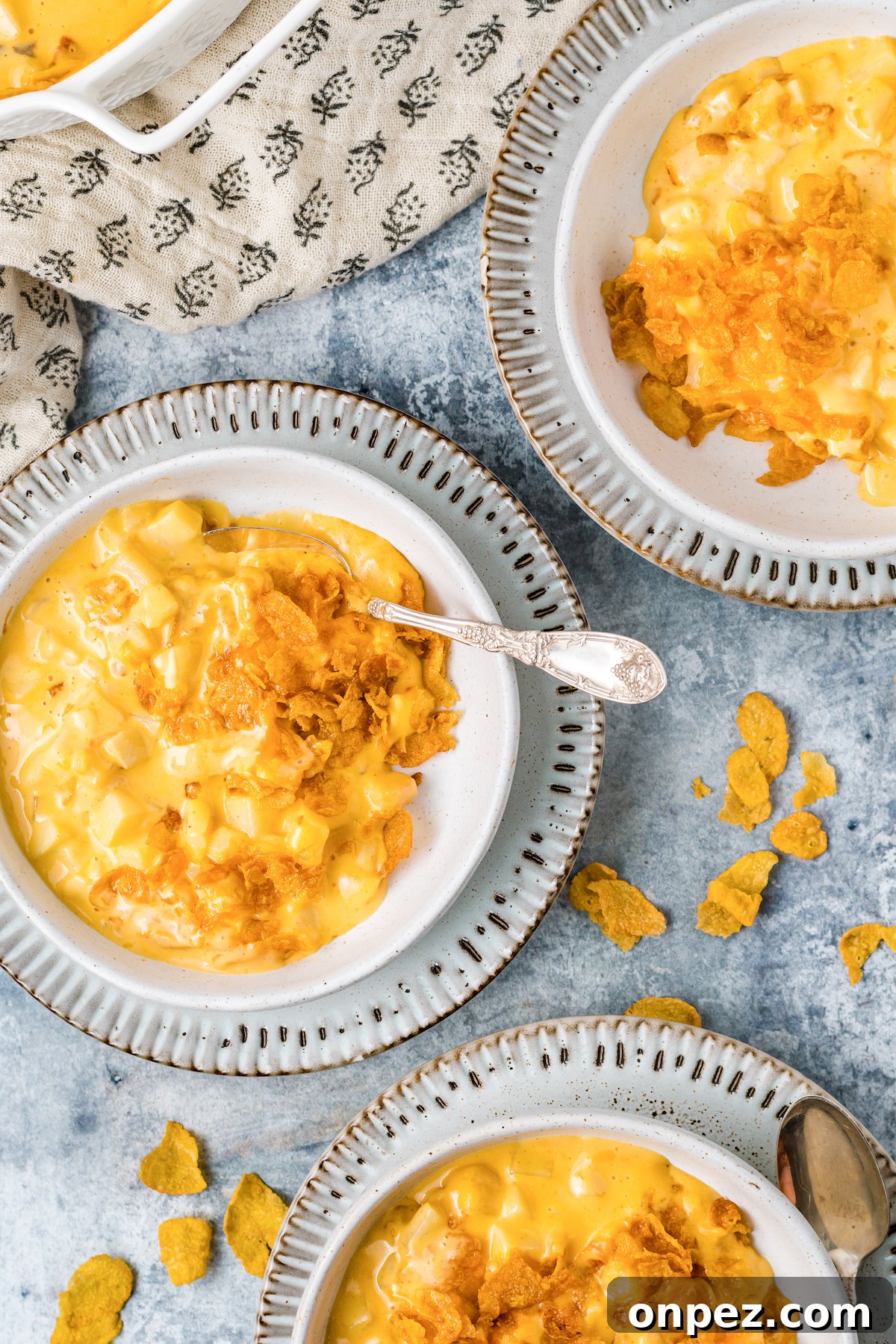Classic Funeral Potatoes: Creamy Hashbrown Casserole Recipe 6 Three soup bowls each filled with a serving of funeral potatoes.