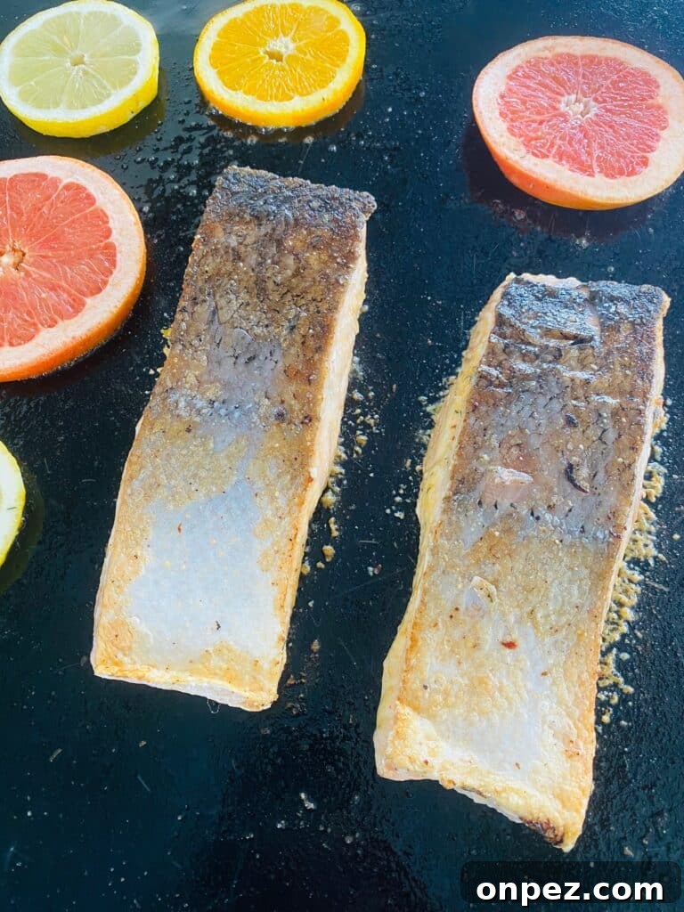 flipping the salmon and adding slices of citrus to the griddle