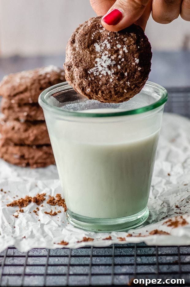 A double chocolate chip cookie dipped in a glass of milk