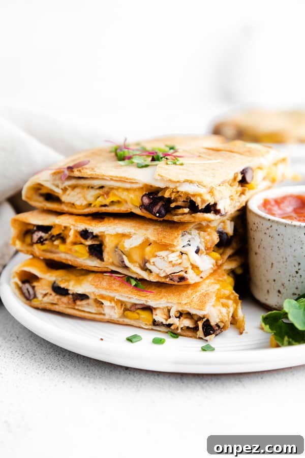 stacked sheet pan chicken quesadillas on a ceramic plate. 