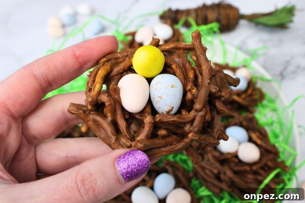 Microwave Easter Bird's Nest Haystacks Recipe 3 holding up a birds nest treat with candy eggs