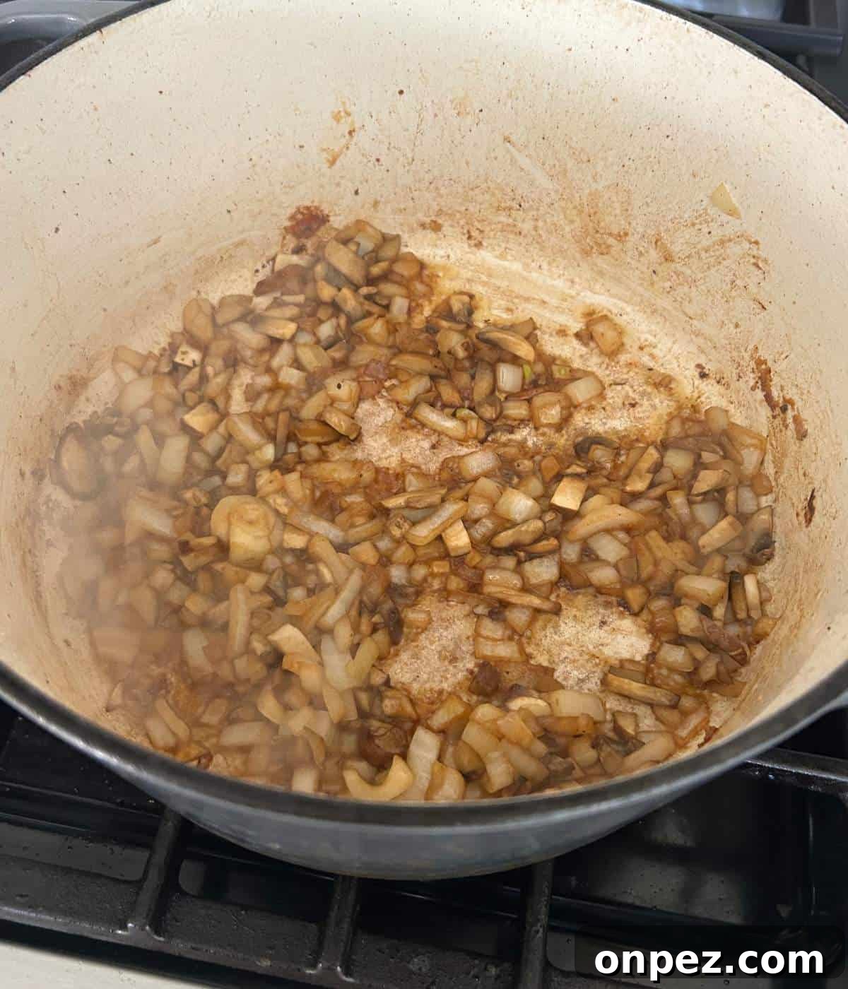 Dutch Oven Pork Chops with Tender Gravy 8 Mushrooms and onions in dutch oven.