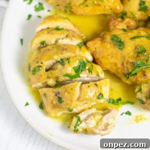 Oven-Baked Maple Mustard Chicken Recipe 4 Maple mustard chicken on a plate with maple mustard sauce topped with freshly chopped parsley. The chicken is cut into slices.