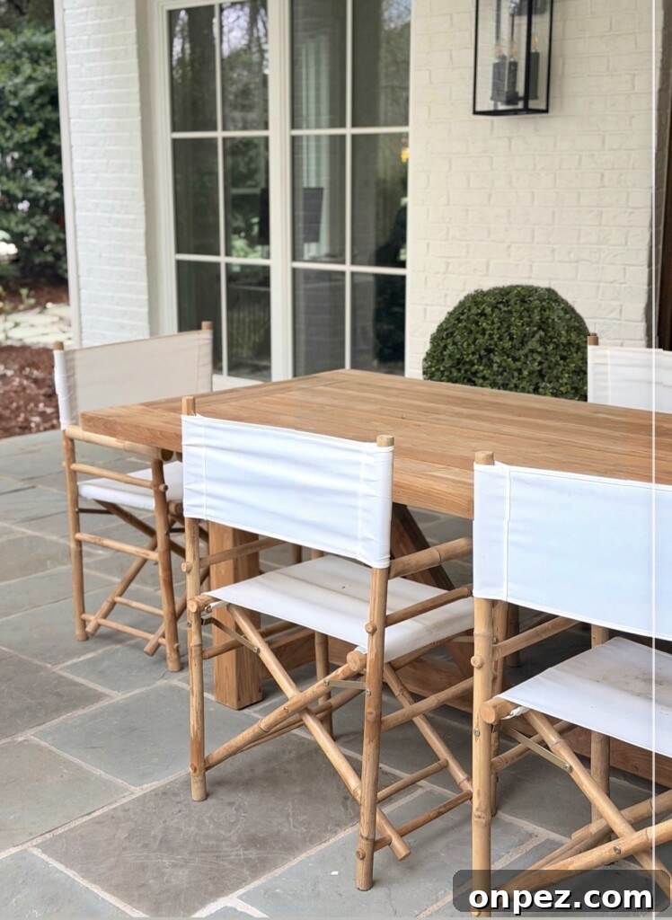 White canvas director chairs around teak table on bluestone patio