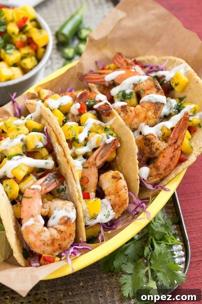 Three tacos filled with shrimp and mango salsa.