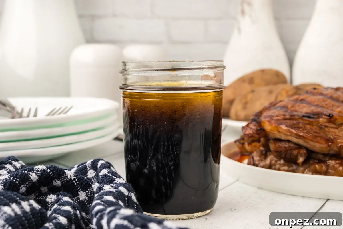 3-Ingredient Steak Marinade for Juicy, Tender Steaks 2 3 ingredient steak marinade in a glass jar with plate stacked with grilled steaks.