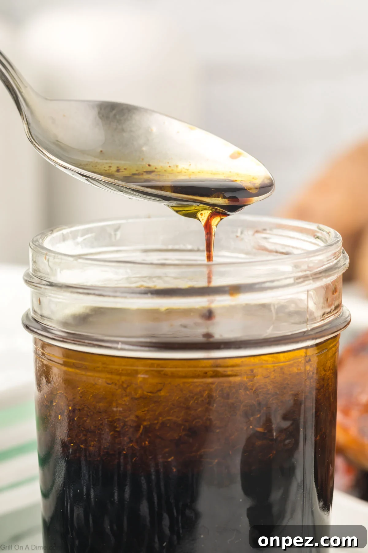 3-Ingredient Steak Marinade for Juicy, Tender Steaks 6 Steak marinade in a jar with a serving on a spoon.