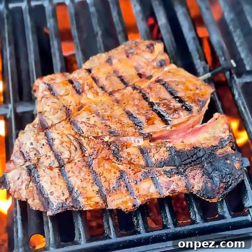 Chuck steak grilling over open flame