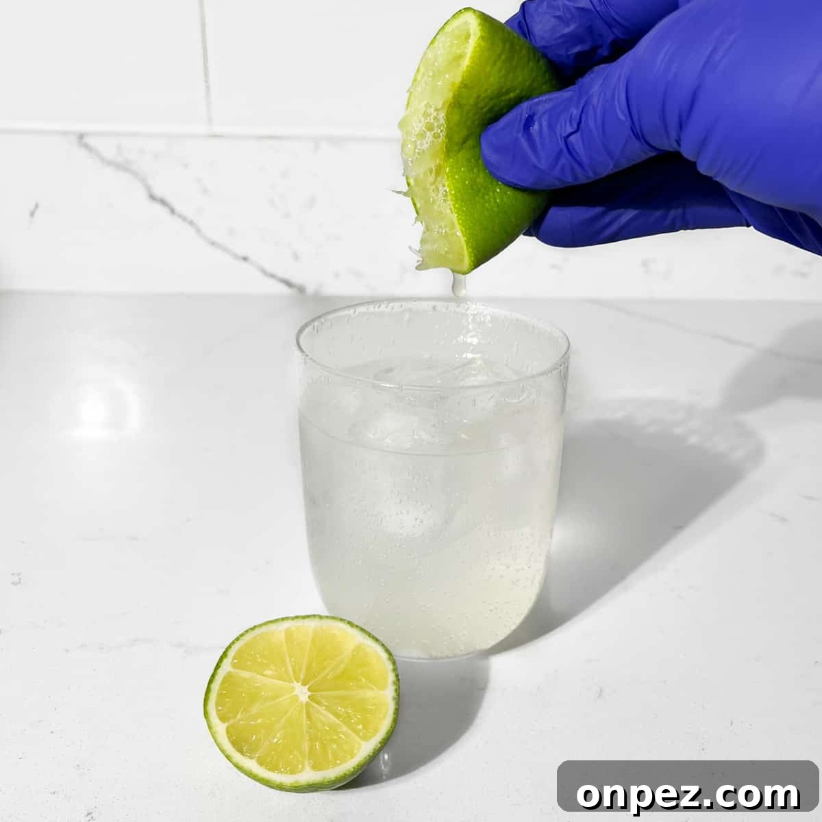 Classic Lemon Lime and Bitters Cocktail Recipe 5 Squeezing lime into a glass.