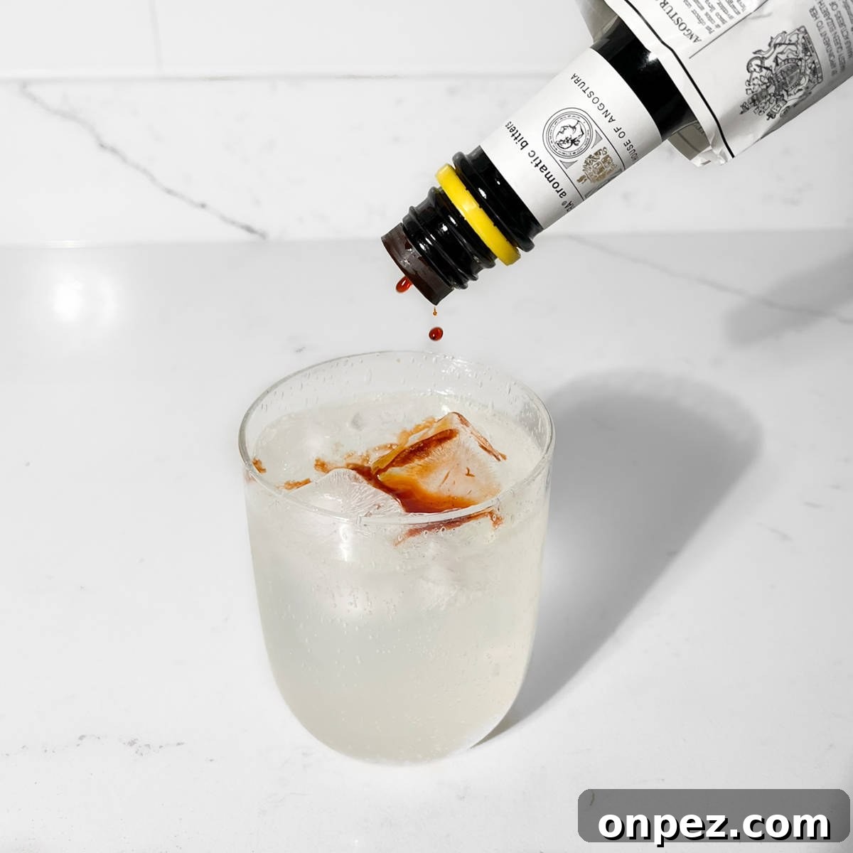 Classic Lemon Lime and Bitters Cocktail Recipe 6 Adding angostura bitters to lemon lime bitters.