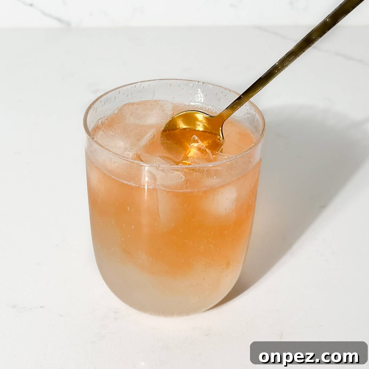 Classic Lemon Lime and Bitters Cocktail Recipe 7 Stirring the lemon lime and bitters with a gold spoon.