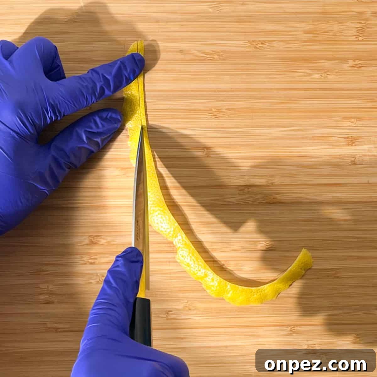 Classic Lemon Lime and Bitters Cocktail Recipe 9 Slicing a long strip of lemon peel for the lemon peel twisty to go on the rock shandy glass.