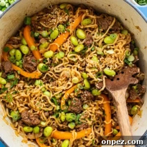A bowl of noodles with meat and vegetables in it.