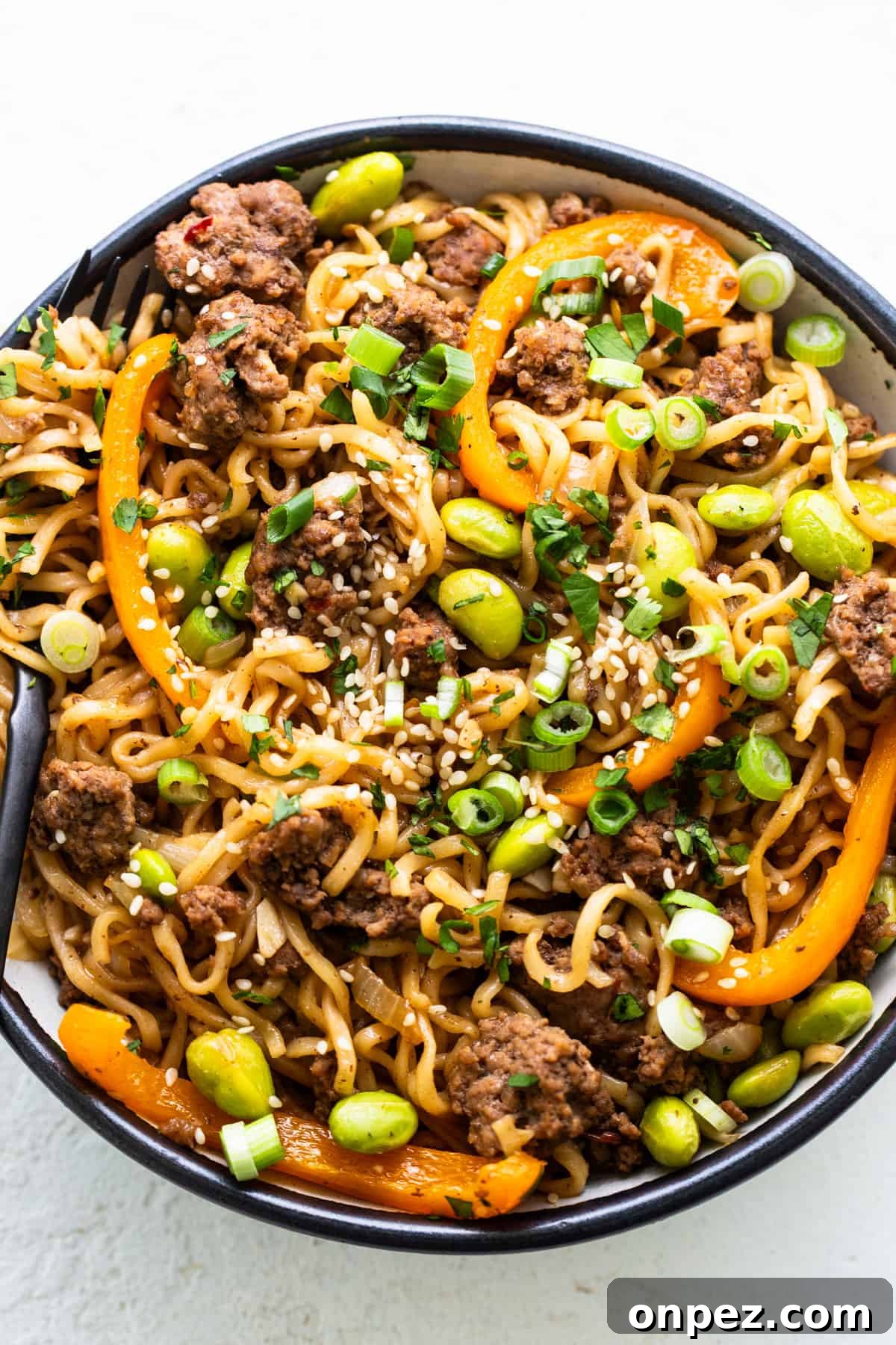 A bowl of noodles with meat and vegetables.