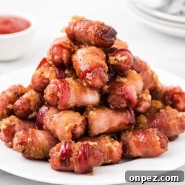 Brown Sugar Bacon-Wrapped Smokies — Crowd-Pleasing Appetizer 8 a close up shot of Bacon Wrapped Smokies staked on top of each other on a plate