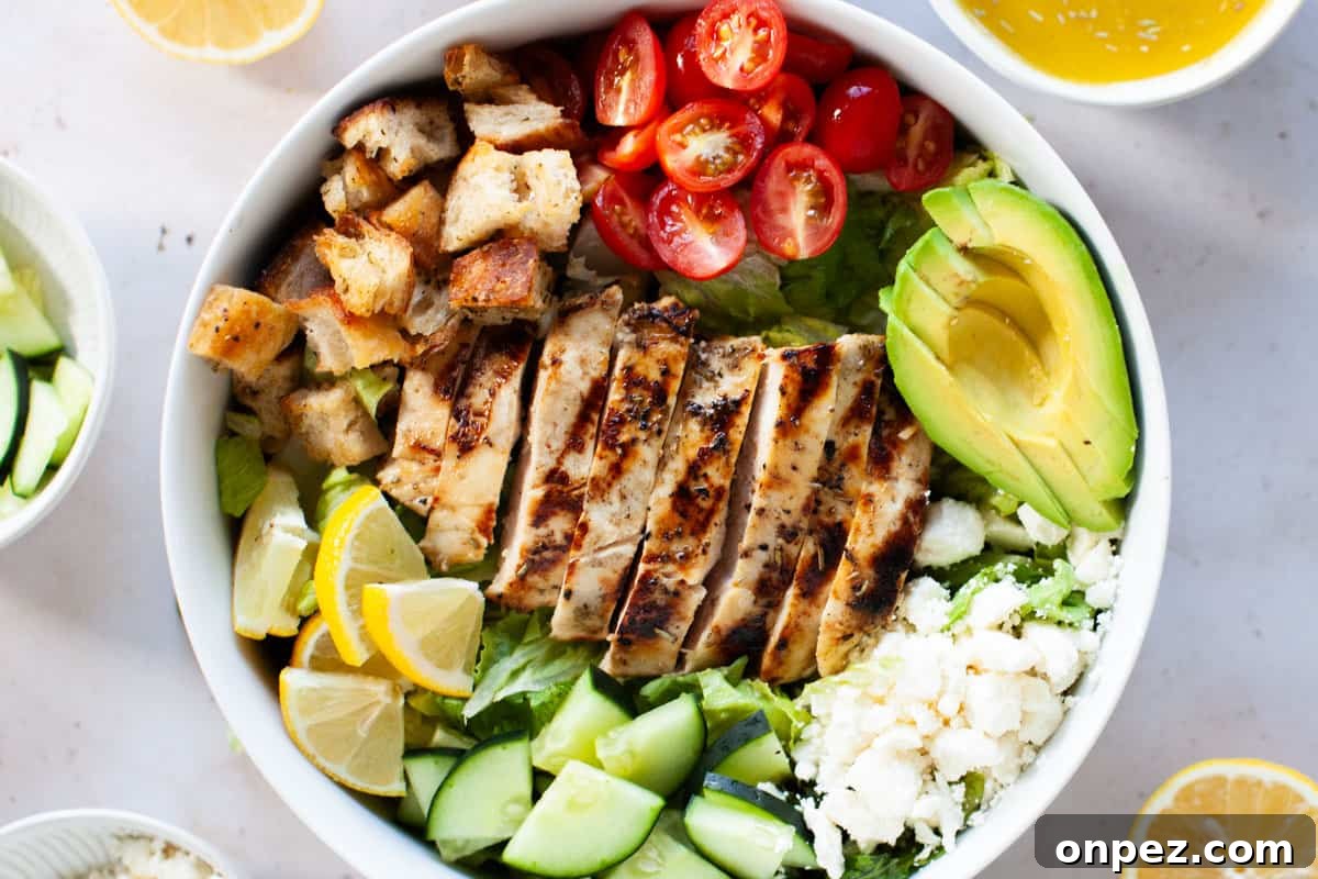 Close up photo of grilled chicken salad in large, white salad bowl.