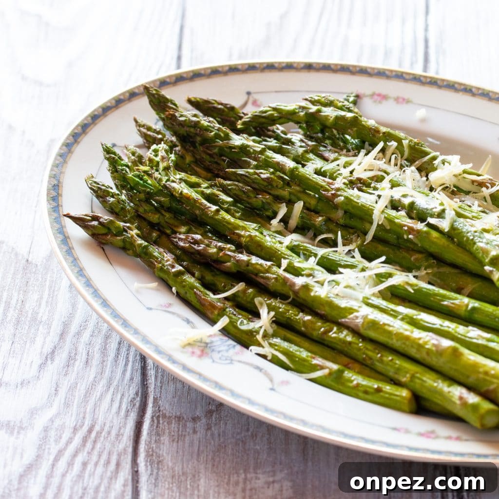 Keto Cream of Asparagus Soup: Low-Carb, Creamy Recipe 3 A plate of asparagus roasted in the air fryer, topped with a little Parmesan cheese.