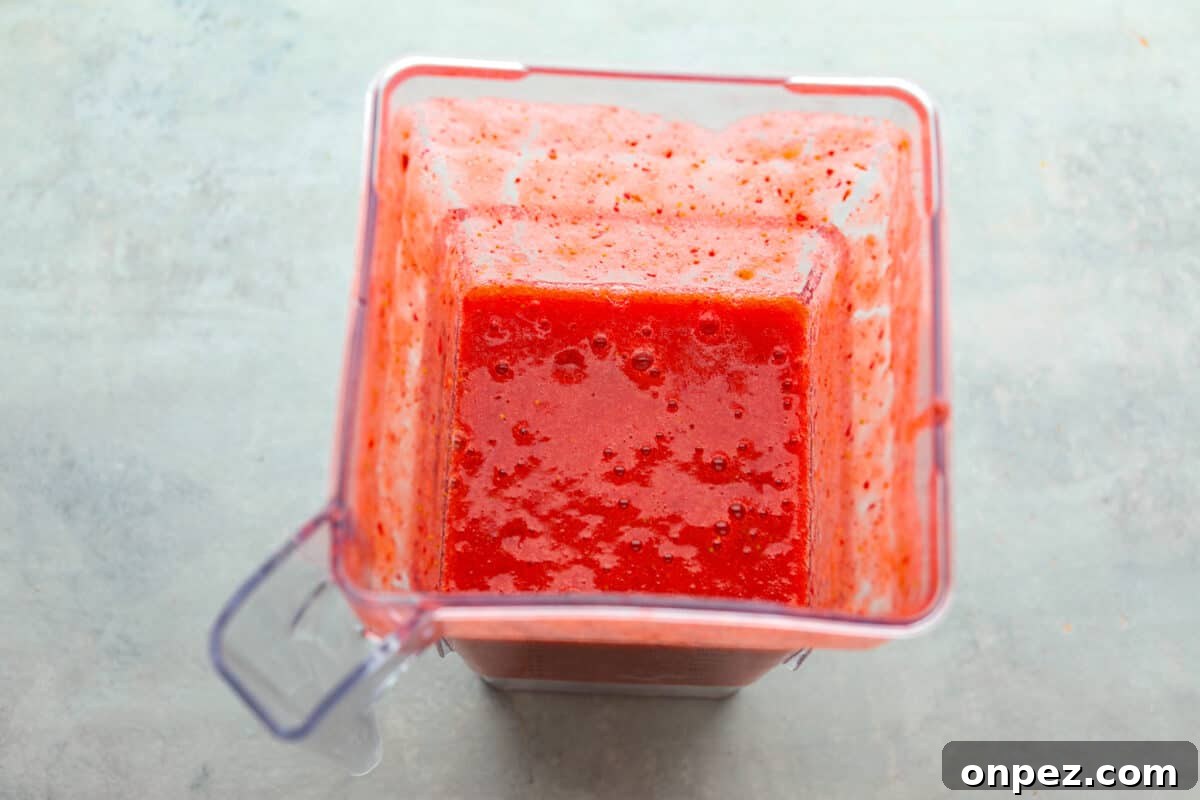 Blend the strawberry puree until smooth. Process photo of the strawberry puree blended in a blender.