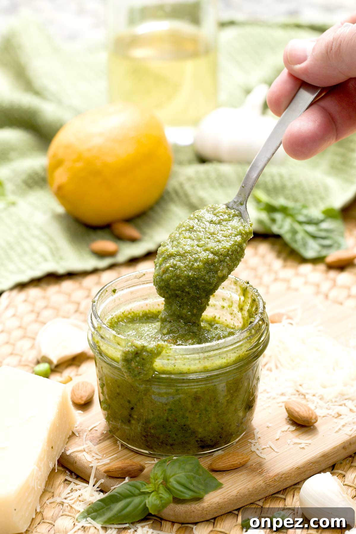 Pesto sauce without pine nuts on a spoon and a mason jar.