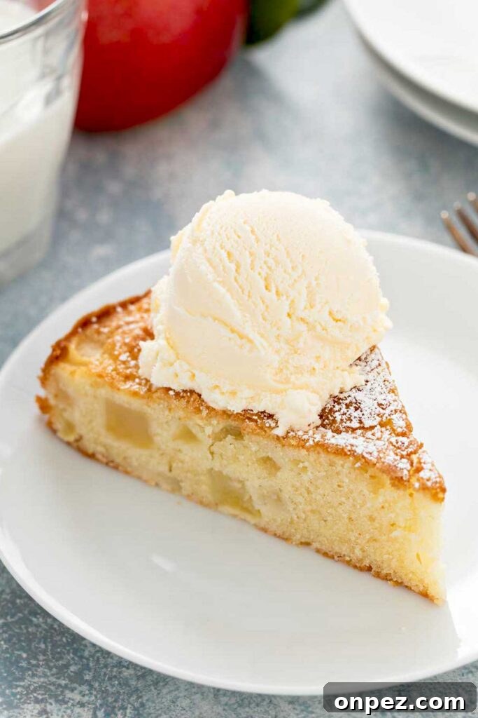 A slice of apple cake topped with vanilla ice cream