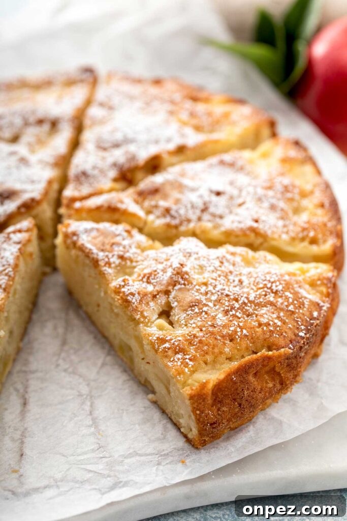 Apple cake cut into big slices on a piece of parchment paper