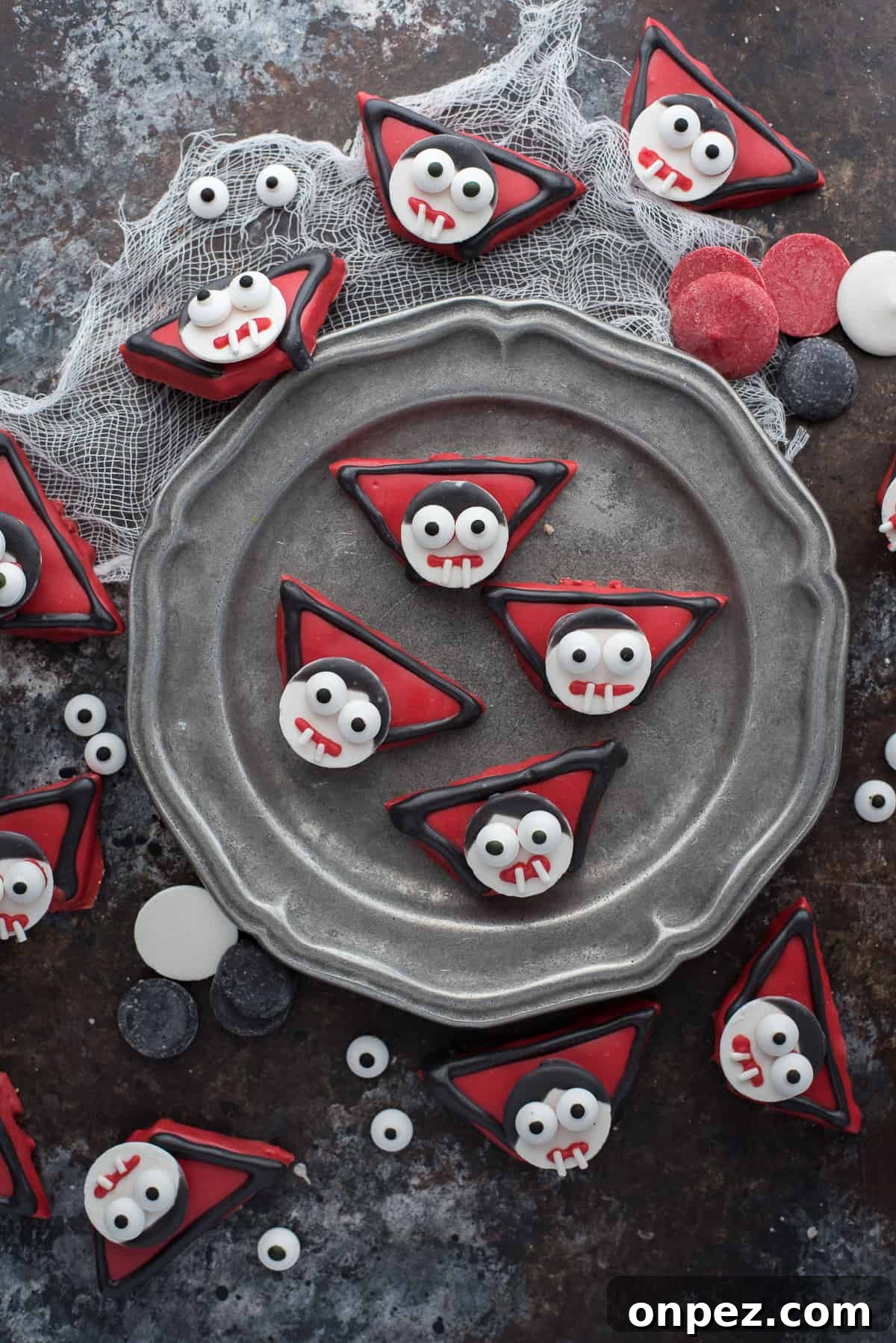 edible vampire treats made out of graham crackers and candy melts displayed on dark background