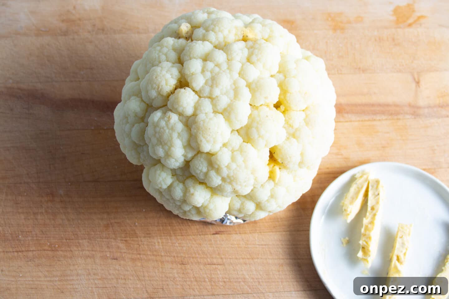 Smoked Cauliflower: How to Achieve Smoky, Tender Flavor 6 Picture of cauliflower being rubbed with butter.