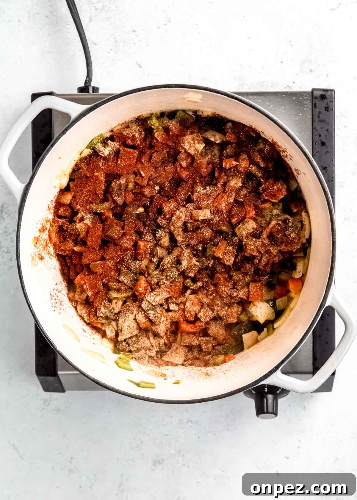 spices covering vegetables in dutch oven