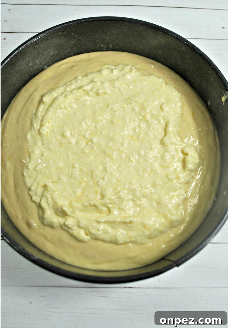 Layering cream cheese filling on blueberry lemon crumb cake recipe
