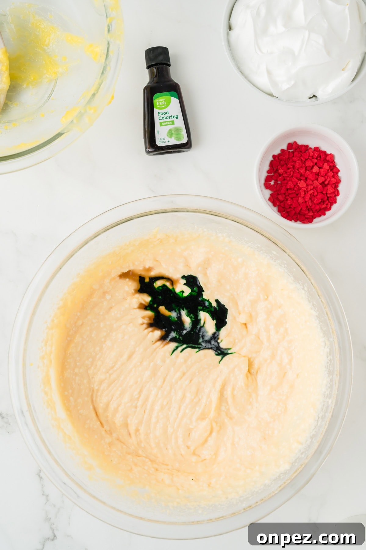 Creamy Grinch Dip Recipe for Holiday Parties 6 An overhead image of adding food coloring to the bowl.