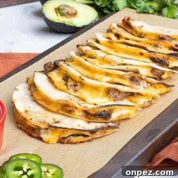Carne asada mulitas on a cutting board with jalapenos and avocado.