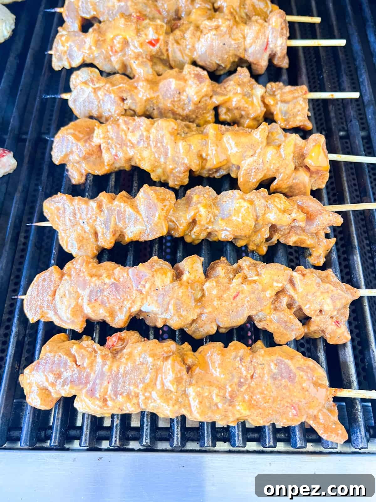 Chicken skewers on grill cooking.