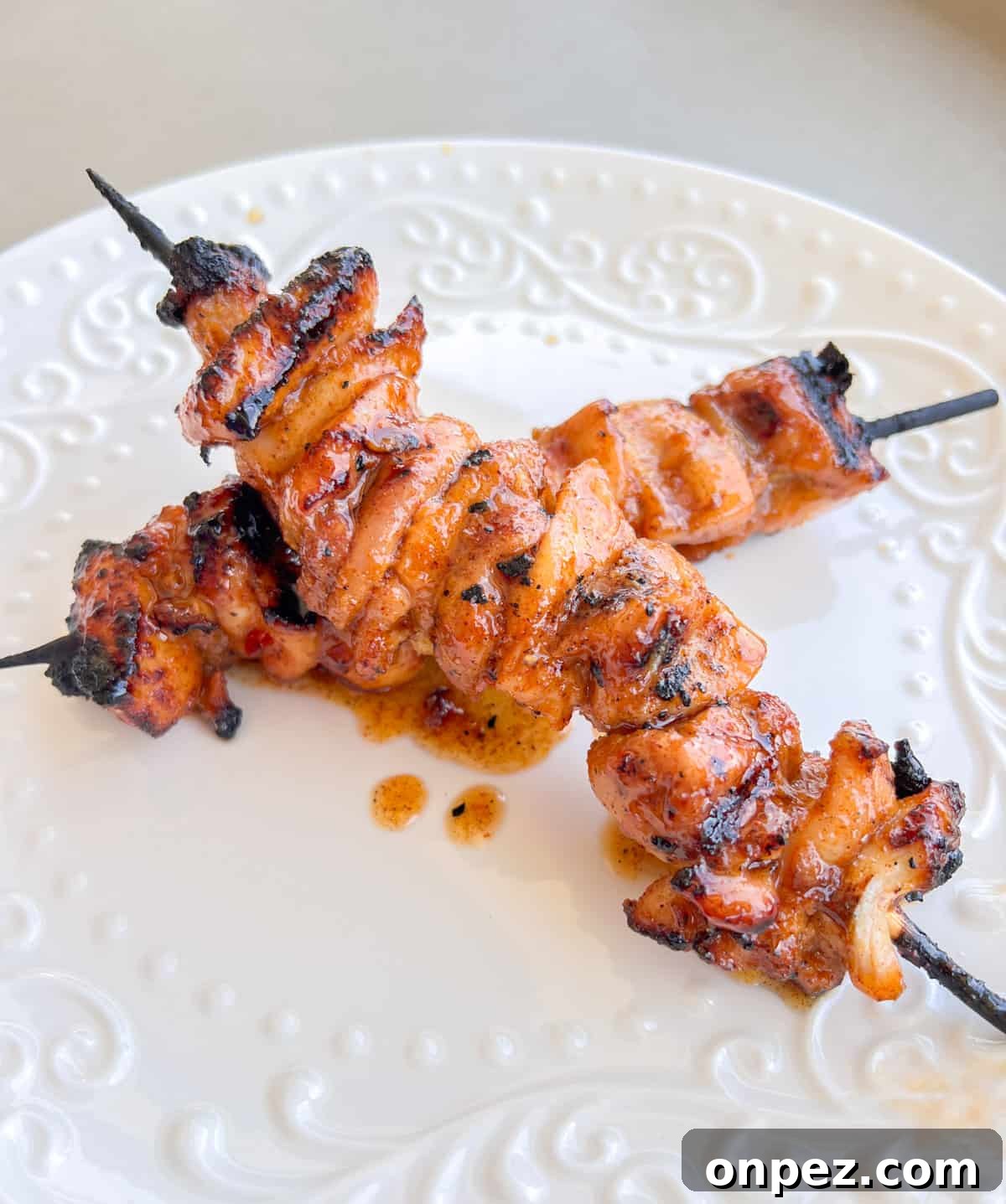 Grilled chicken kabobs on a plate.