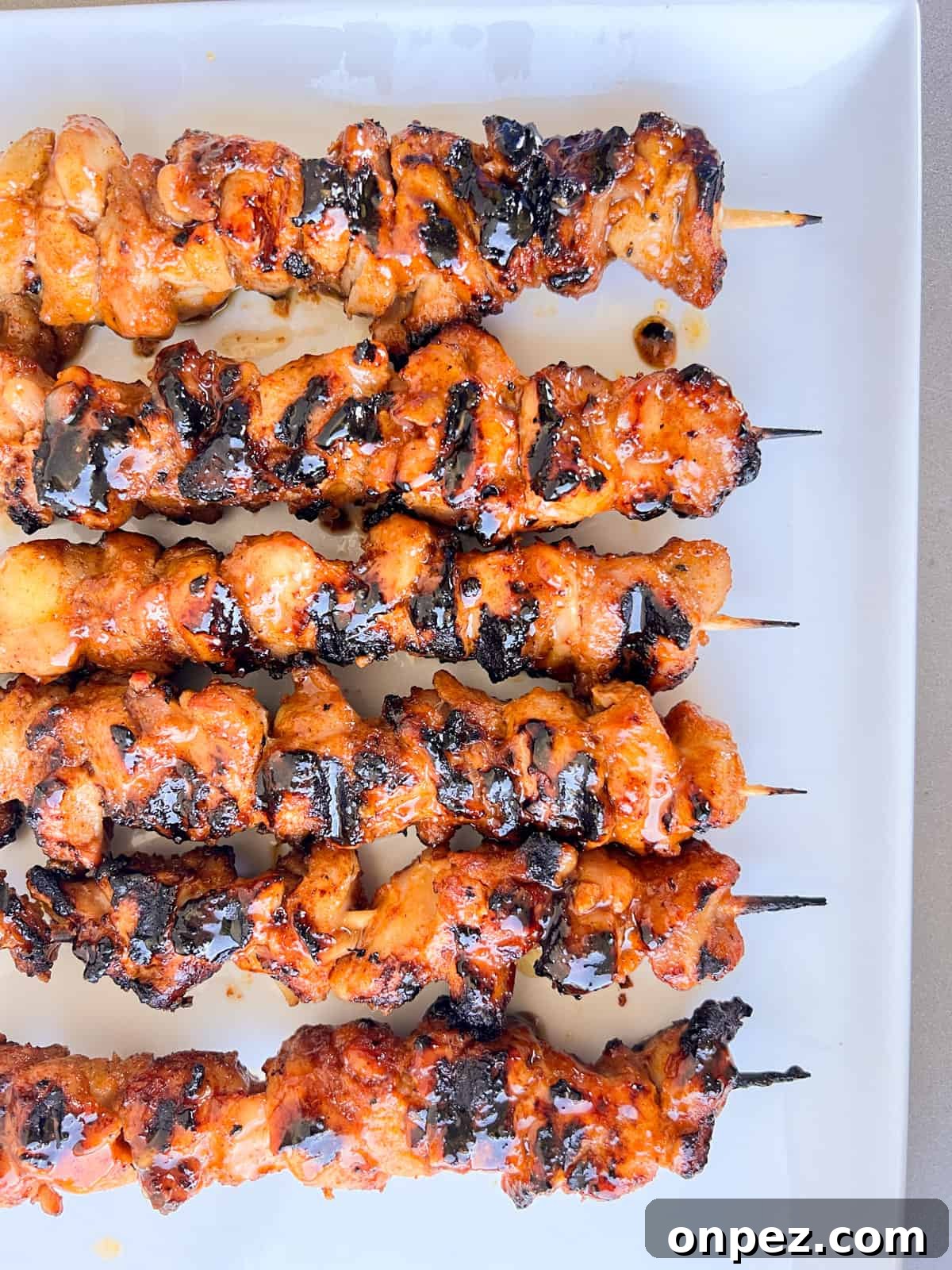 Chicken kabobs on plate with glaze.