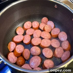 Authentic New Orleans Red Beans and Rice 4 Sausage being browned in a pot.
