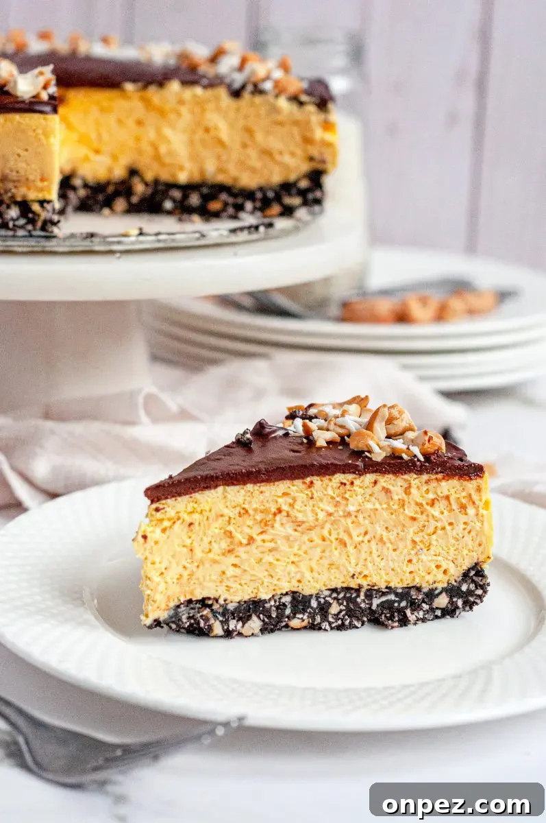 No-Bake Vegan Gluten-Free Nanaimo Bar Cheesecake 6 A no-bake nanaimo bar cheesecake. it has three layers. The bottom layer is a chocolate crust, the middle layer is a yellow custard cheesecake, and the top is a thin layer of dark chocolate topped with white shredded coconut and yellow salted cashews. There is a slice of this cheesecake sitting on a white plate in front.
