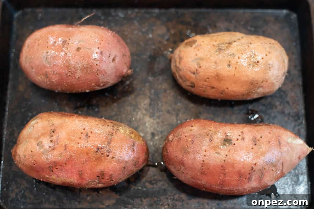 Sweet potatoes brushed with oil and salt on baking sheet.
