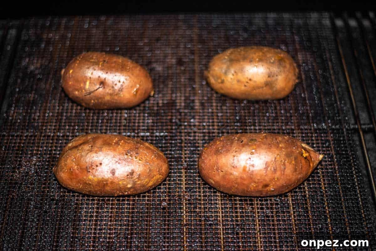 4 cooked sweet potatoes in smoker.