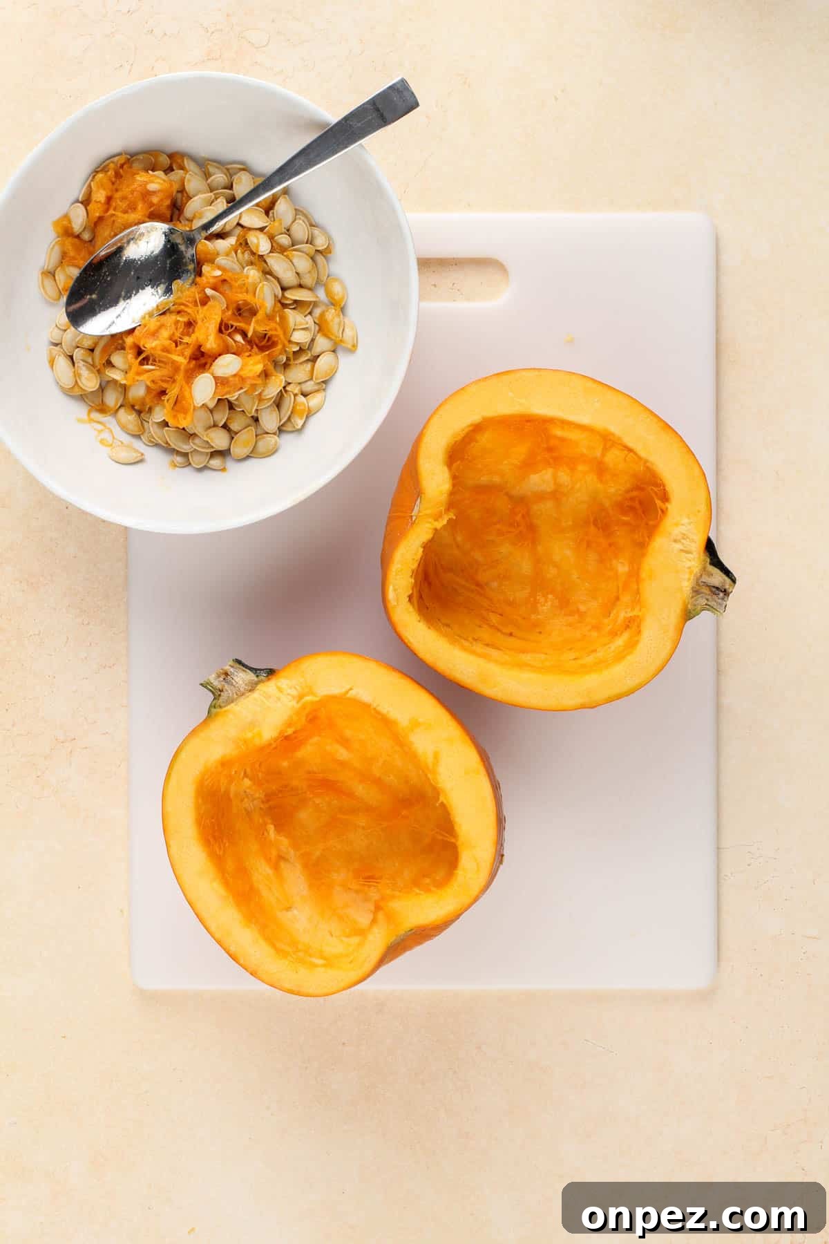 a pie pumpkin cut in half on a cutting board