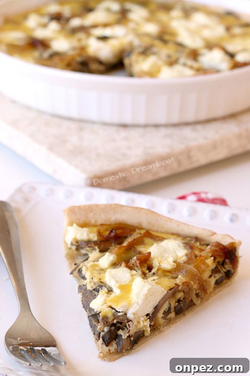 Caramelized Onion and Sauteed Mushroom Quiche on a white plate.
