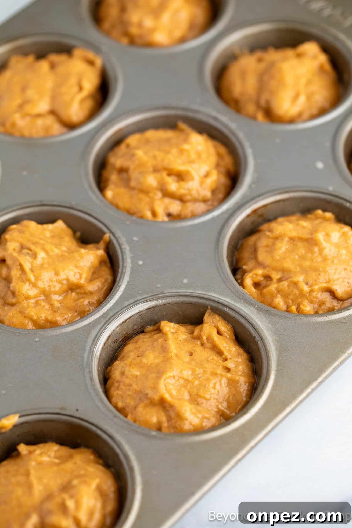 Pumpkin Banana Muffins Recipe with Warm Fall Spices 5 Muffin batter in a muffin tin.