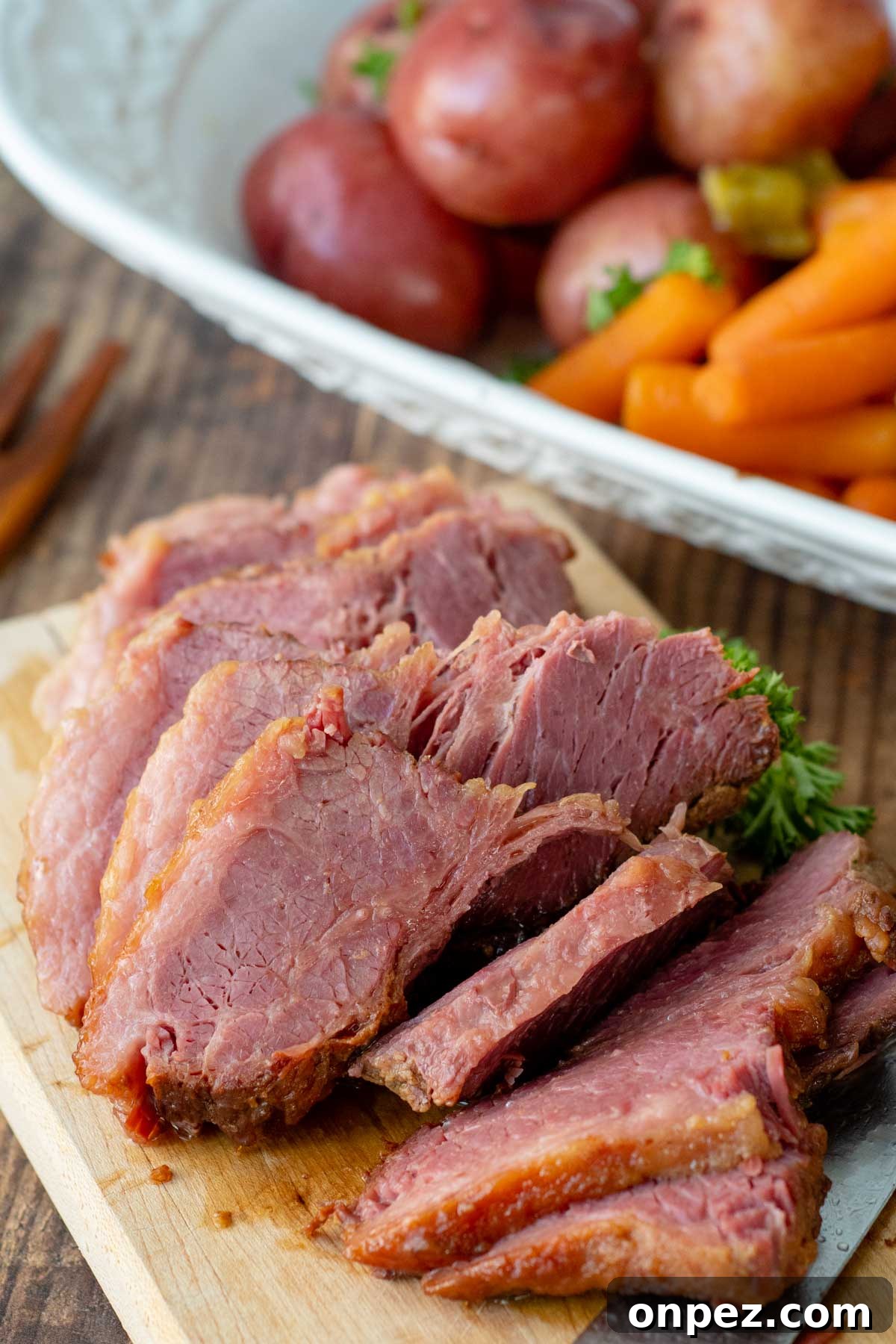 Brown Sugar Corned Beef and Cabbage with Apple Juice 4 sliced corned beef on a wooden cutting board