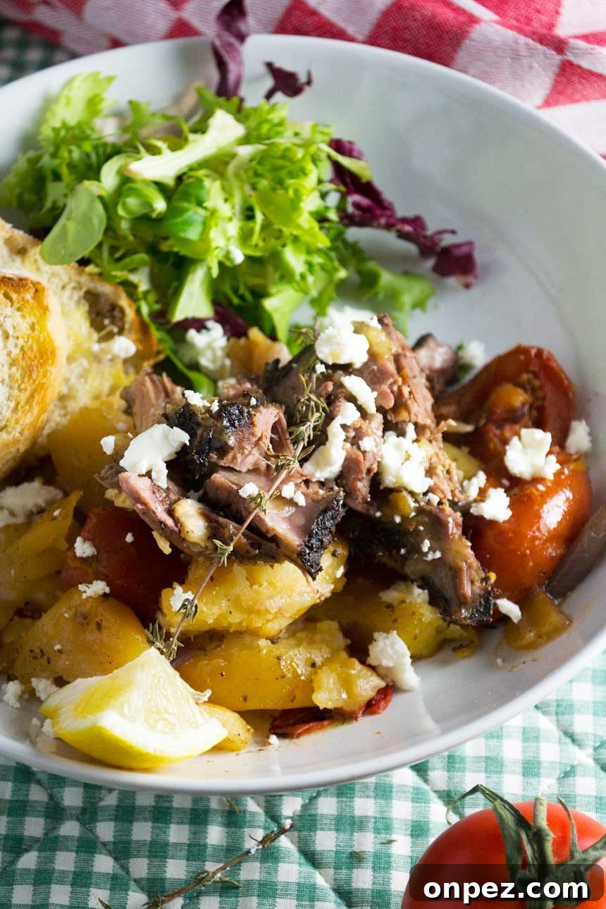 A big white plate of Greek lamb with lemony garlic potatoes (lamb kleftiko) close up