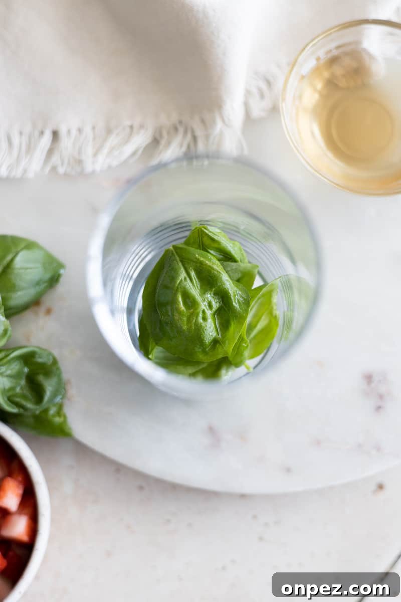 Basil in the bottom of a highball glass. 
