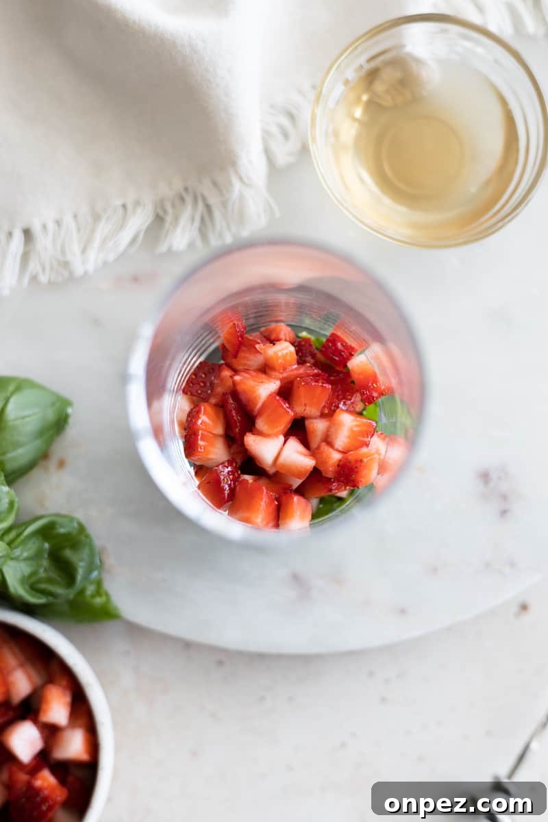 Strawberries in the bottom of a highball glass. 