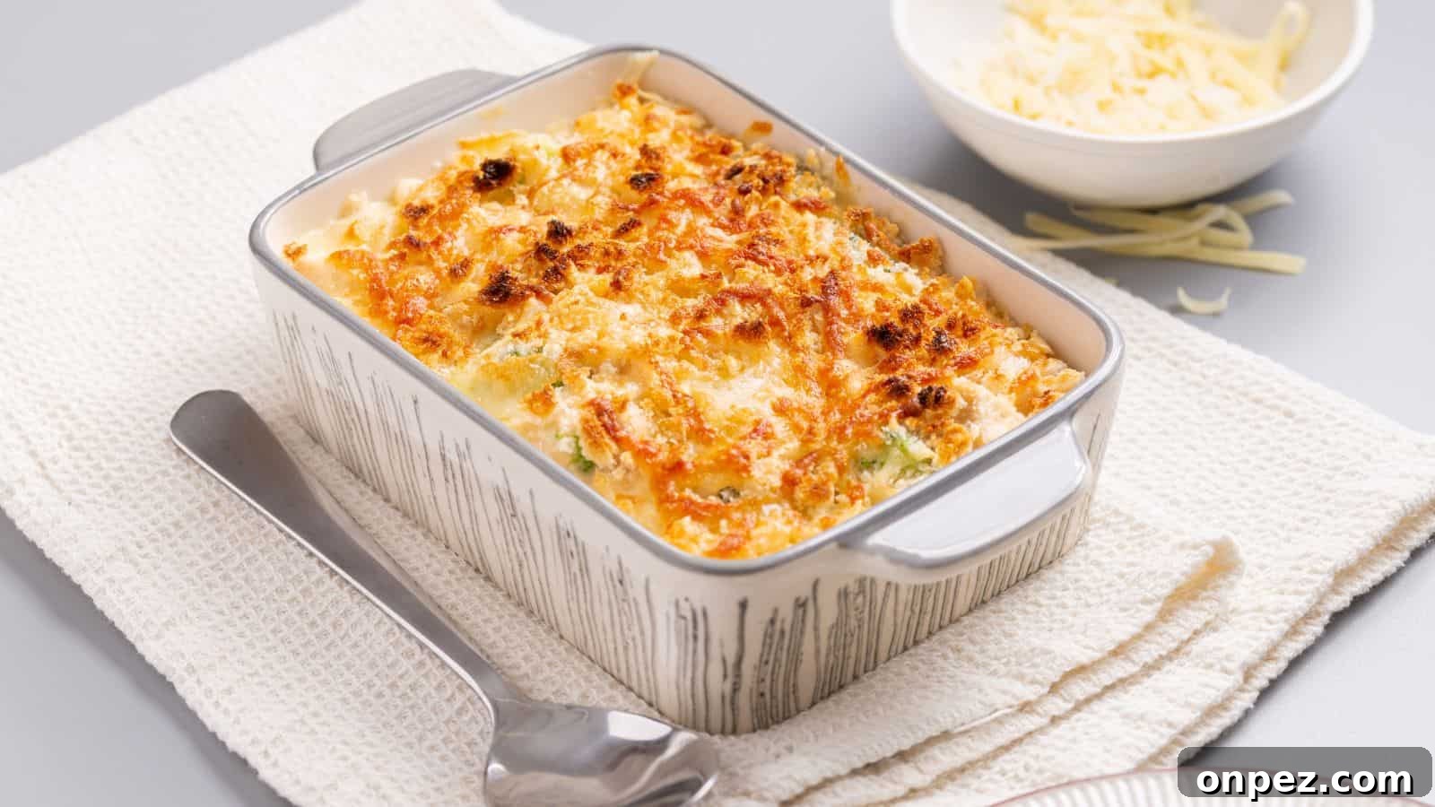 A casserole dish with cheese and broccoli on a napkin.