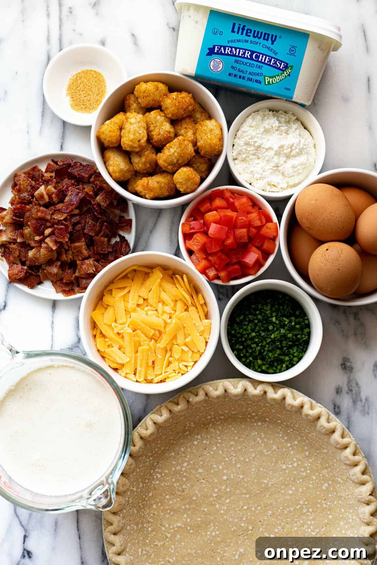 Quick Breakfast Quiche Recipe 3 White marble counter top with bowls of ingredients to make a breakfast quiche.