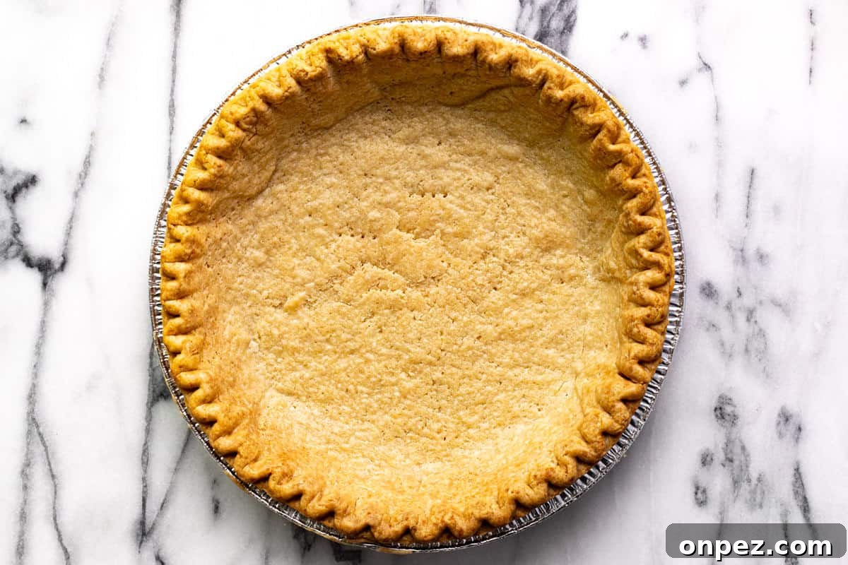 Quick Breakfast Quiche Recipe 5 A blind baked pie crust in an aluminum pan.