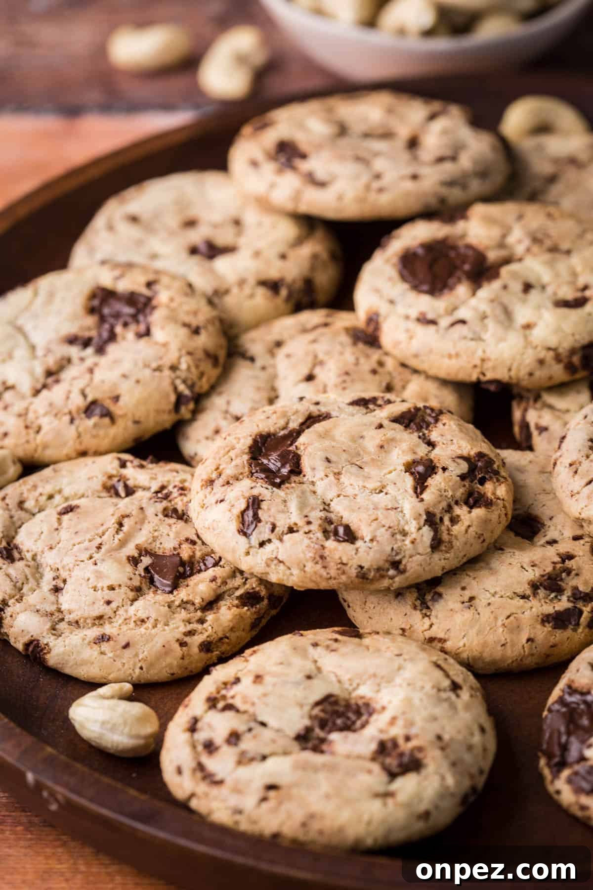 A pile of Cashew Butter Cookies with molten chocolate puddles.
