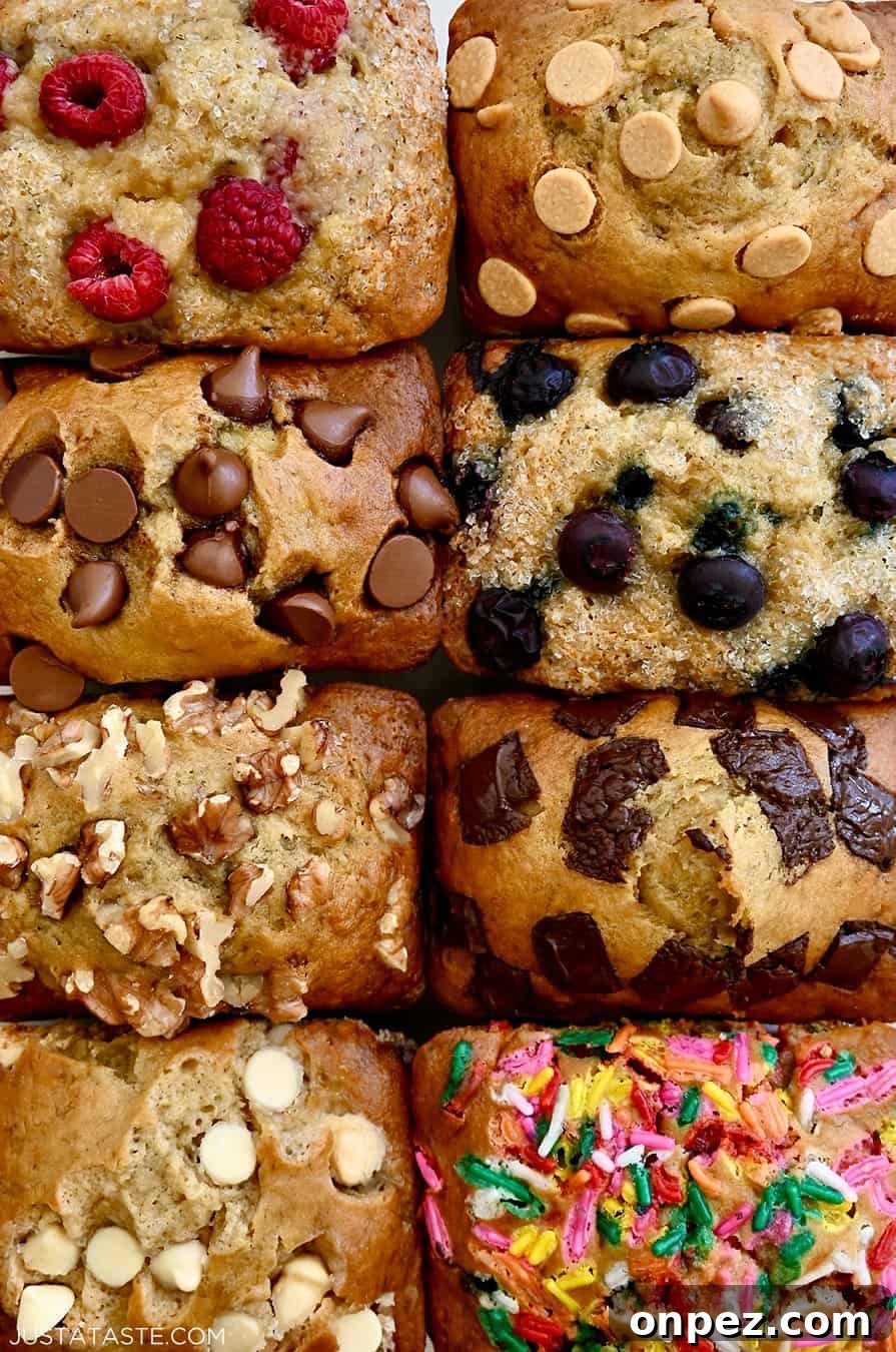 A close-up view of moist mini banana bread loaves all topped with different ingredients, including fresh berries, chocolate chips, walnuts and rainbow sprinkles